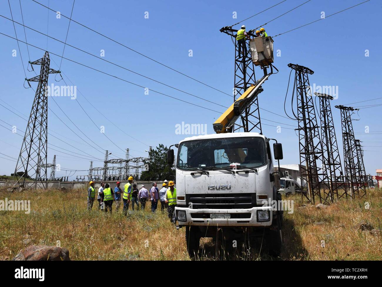 (190605) - homs, Juni 5, 2019 (Xinhua) - Weibliche elektrische Arbeiter der Fix eine hohe Spannung Strom Linie in Homs Provinz Syrien am 30. Mai 2019. Als der Krieg in Syrien polterte, syrische Frauen begannen in mehr Arbeitsplätze als reguläre Arbeit und Kindererziehung, als viele Männer hatte die Armee oder das Land Zuflucht zu suchen. Die Jobs, die Frauen im Land zunehmend Tun gehören die Reparatur von Autos, fahren Busse oder Taxis, und interessanterweise mit einem Kran die Hochspannungsleitungen zu erreichen und sie zu beheben, trotz aller Herausforderungen wie der Familie opp Stockfoto