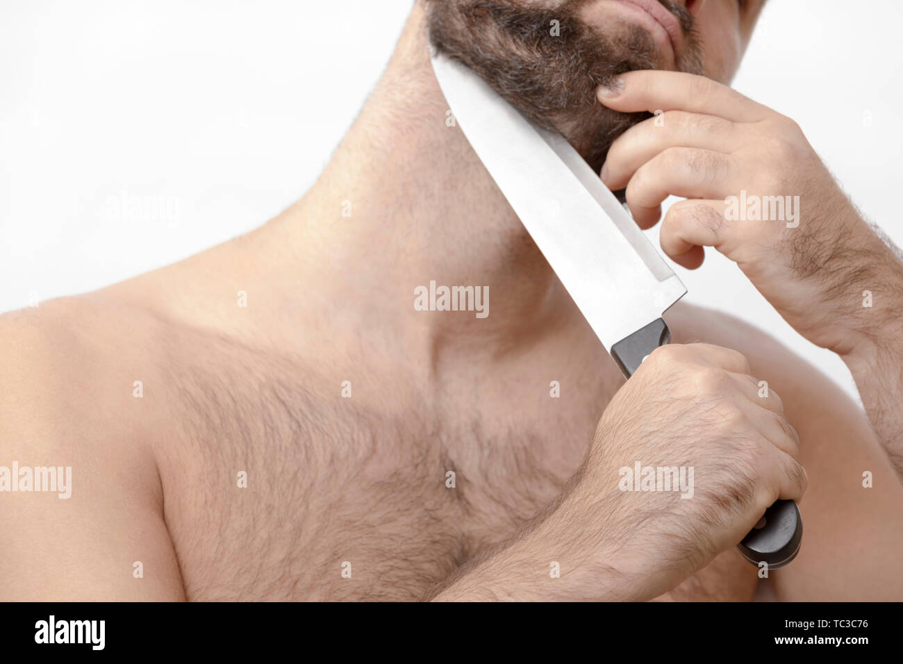 Mann rasiert sich den Bart mit einem Messer Stockfoto