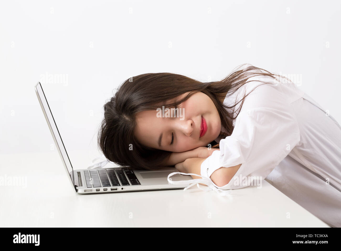 Weibliche Angestellte liegen auf dem Computer. Stockfoto