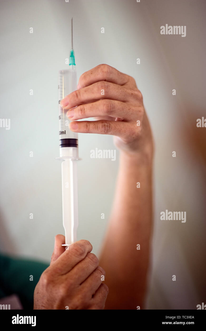 7/8-Ansicht einer Krankenschwester mit einer Spritze in der Hand. Stockfoto
