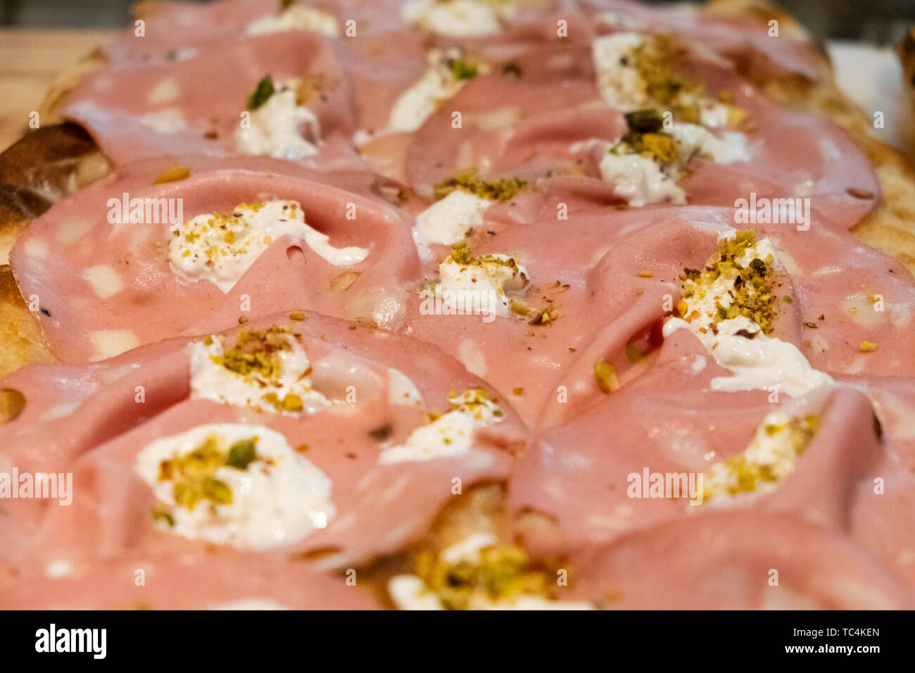 Im römischen Stil Pizza in Pala, hohe idration, von der Scheibe in einer gourmet Pizzeria in Rom verkaufen, Mortadella Schinken, burrata Käse, Pistazie, Olivenöl, es Stockfoto
