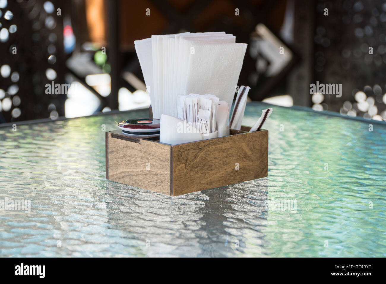 Box mit Papier Servietten auf einem Glastisch, close-up. Teil der Tabelle Einstellung im Sommer Cafe Stockfoto