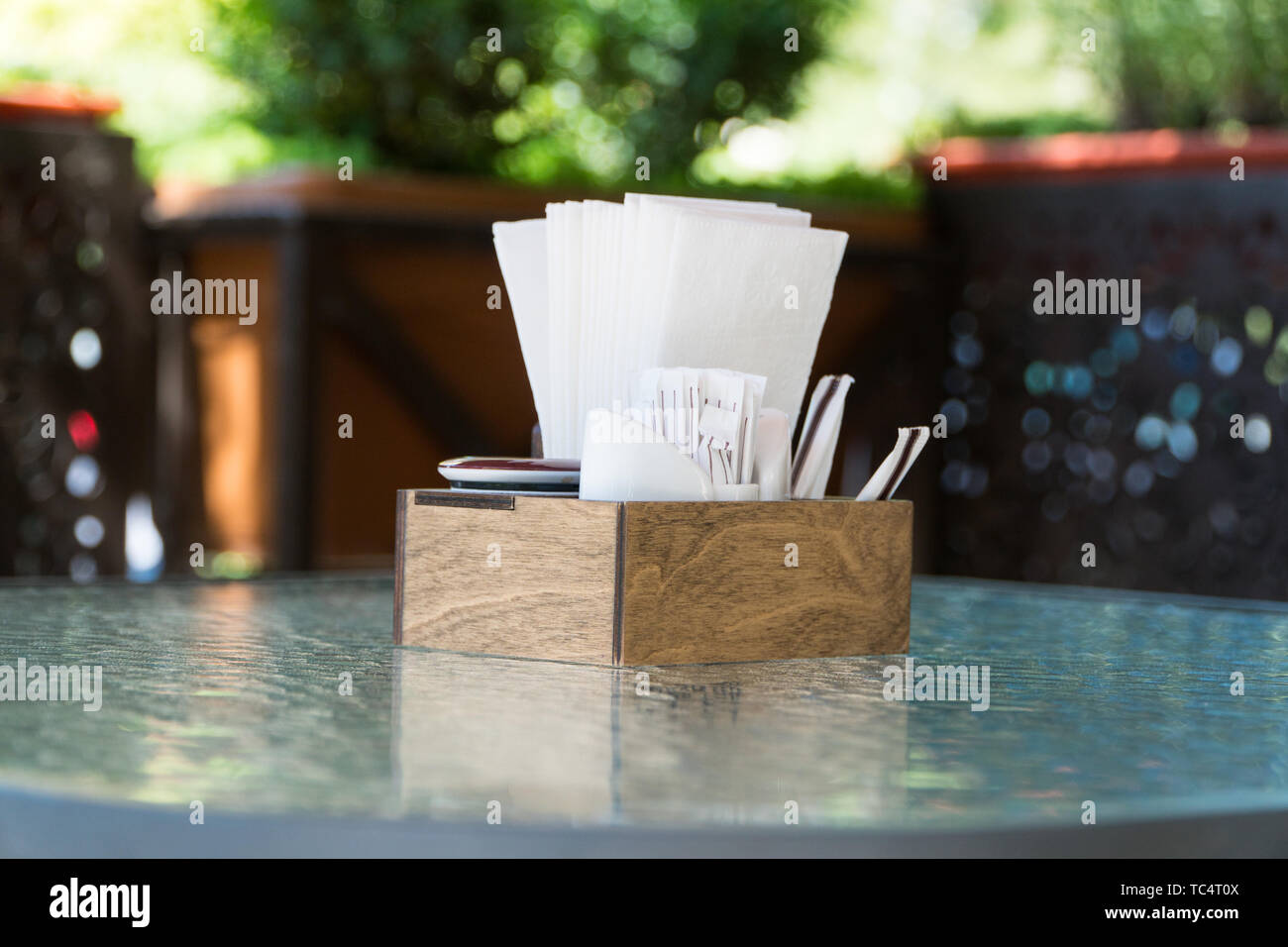 Box mit Papier Servietten auf einem Glastisch, close-up. Teil der Tabelle Einstellung im Sommer Cafe Stockfoto