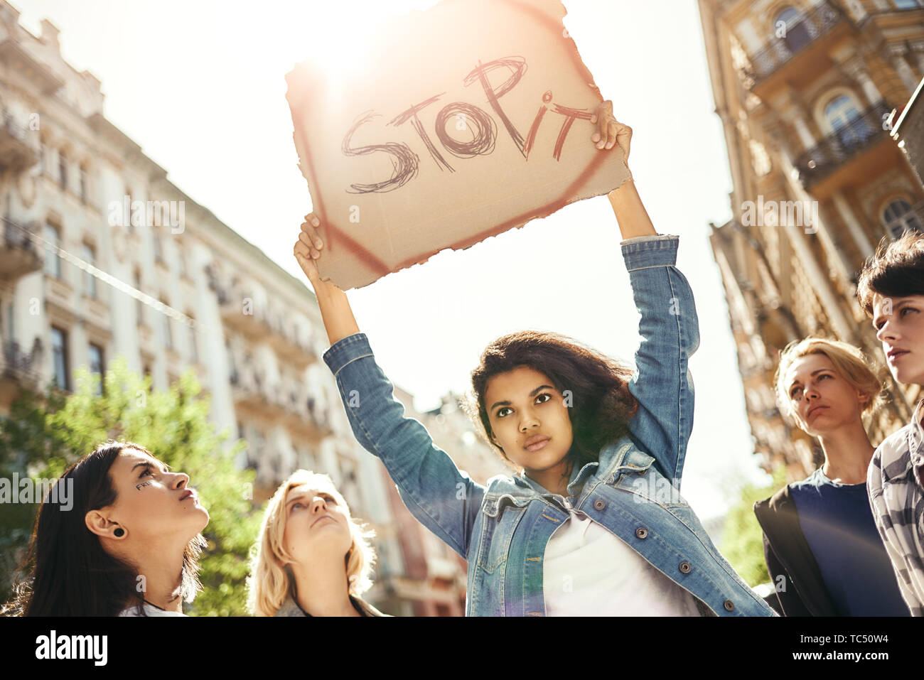 Macht Liebe, nicht Krieg. Starke junge Frau mit einem Namensschild in Wort Stop es ihr über den Kopf und stehen auf der Straße um Aktivistinnen. Rechte der Frau. März der Frauen. Menschenrechte Stockfoto