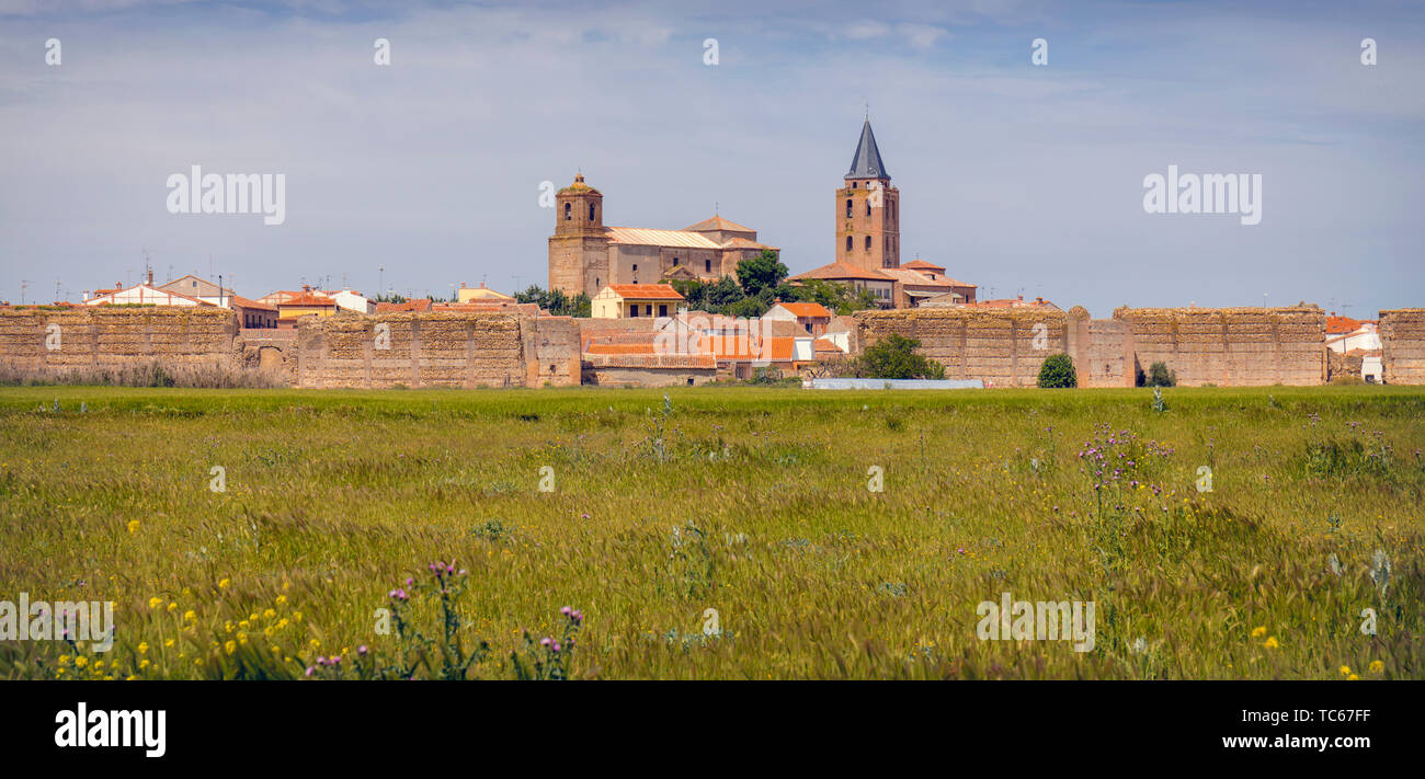 Blick über die Felder, um Reste der Mauern der Madrigal de las Altas Torres, Provinz Avila, Kastilien und Leon, Spanien. Die Kirche auf der linken Seite ist San Stockfoto
