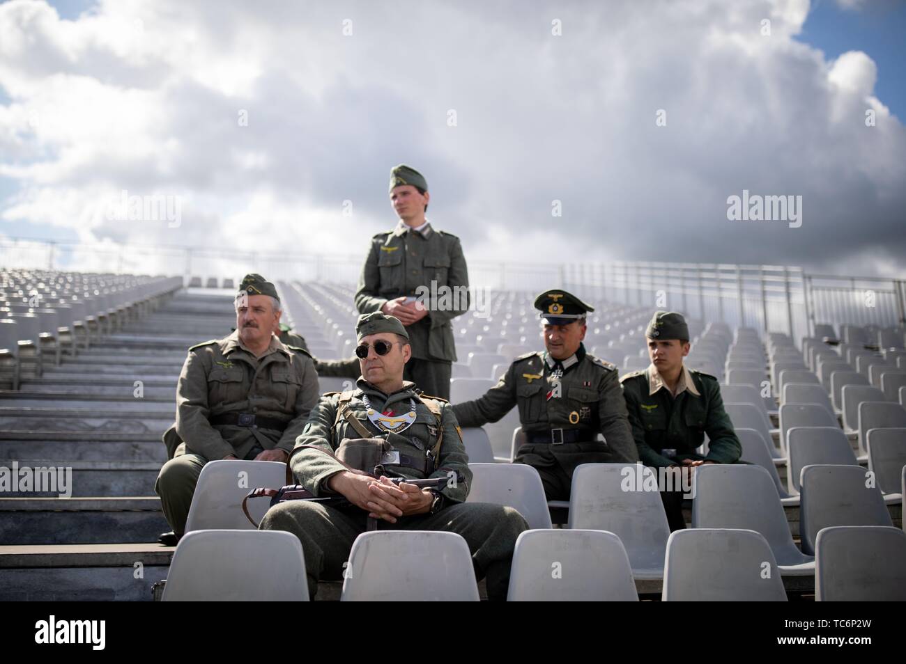 Merville, Frankreich. 06 Juni, 2019. Zum 75. Jahrestag der Landung der alliierten Truppen in der Normandie, Franzosen in deutschen Uniformen sitzen auf einer Tribüne auf dem Gelände der Artillerie Batterie. Die Region erinnert an den 75. Jahrestag der Landung der alliierten Truppen in der Normandie. Foto: Kay Nietfeld/dpa Quelle: dpa Picture alliance/Alamy leben Nachrichten Stockfoto