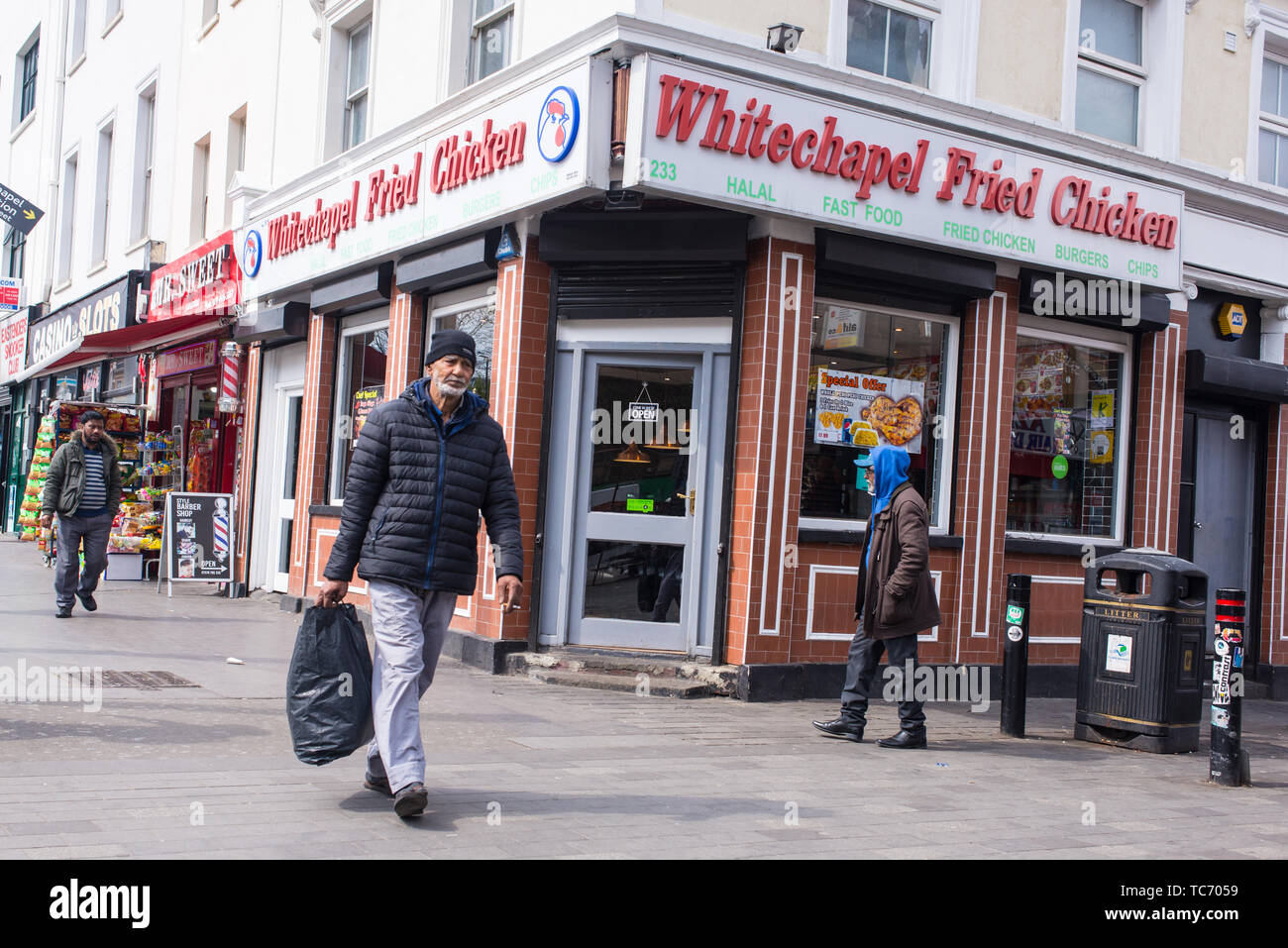 Whitechapel, London, England, UK - April 2019: Whitechapel Fried Chicken Shop mit Menschen zu Fuß in fornt auf der Whitechapel Road, Shadwell, London Stockfoto