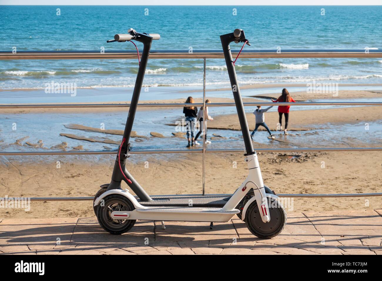 Elektroroller und die Menschen im Hintergrund. Strand von Castellon.  Gemeinschaft Valencia. Spanien Stockfotografie - Alamy