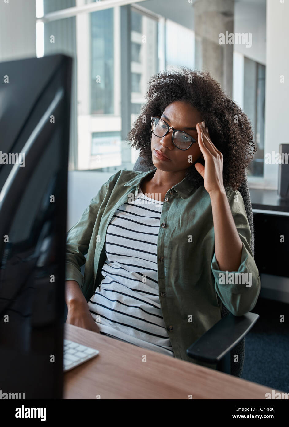 Müde, gestresste Geschäftsfrau am Computer in einem Büro suchen Stockfoto