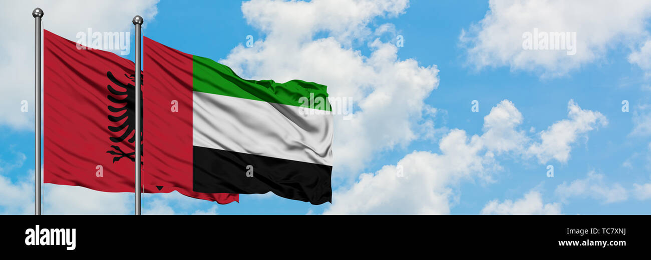 Albanien und der Vereinigten Arabischen Emirate Flagge im Wind gegen Weiße bewölkt blauer Himmel zusammen. Diplomatie Konzept, internationale Beziehungen. Stockfoto