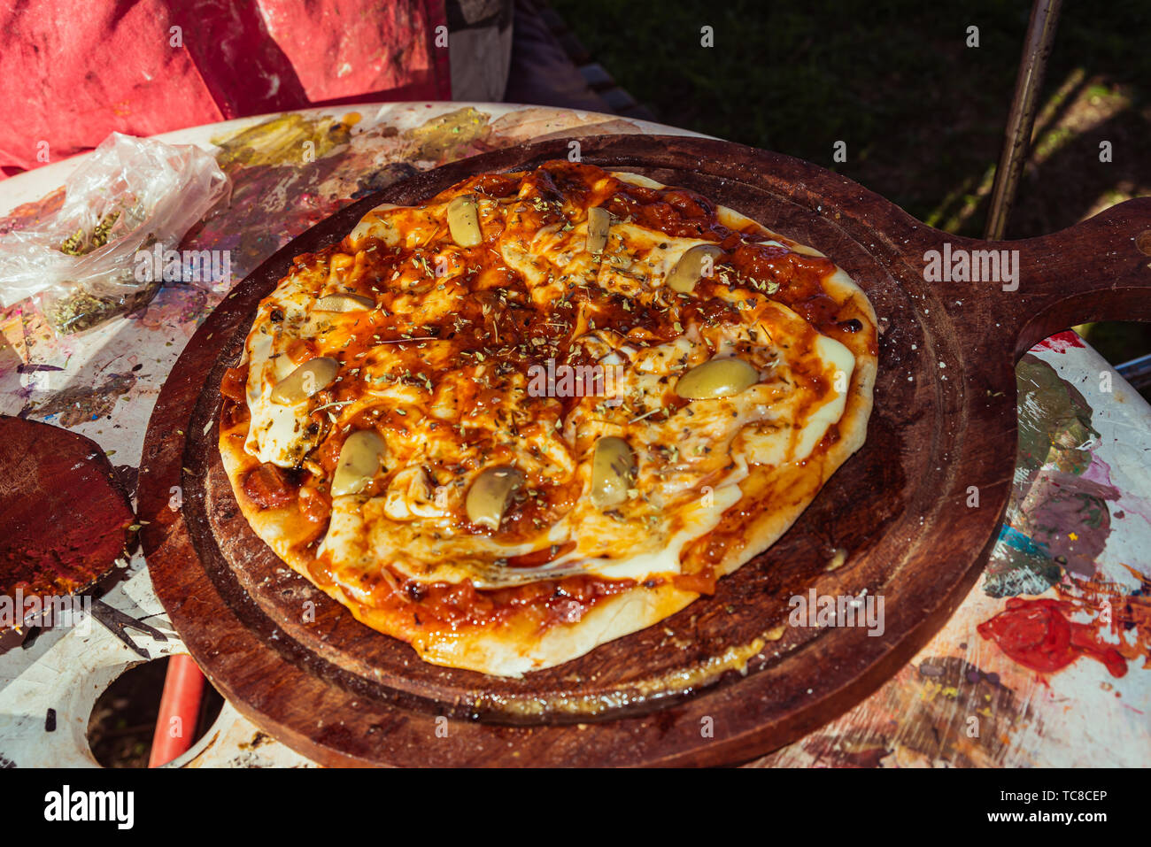 Grobe hausgemachte vegetarische Pizza mit Tomaten, Basilikum, Oliven und Käse auf dem Grill gemacht Stockfoto