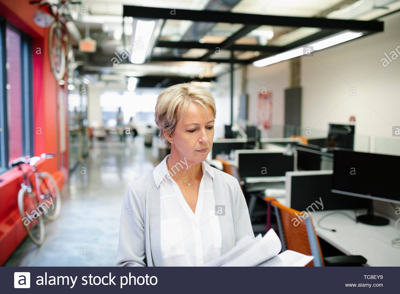 Geschäftsfrau Wandern und Lesen Schreibarbeiten im Büro Stockfoto