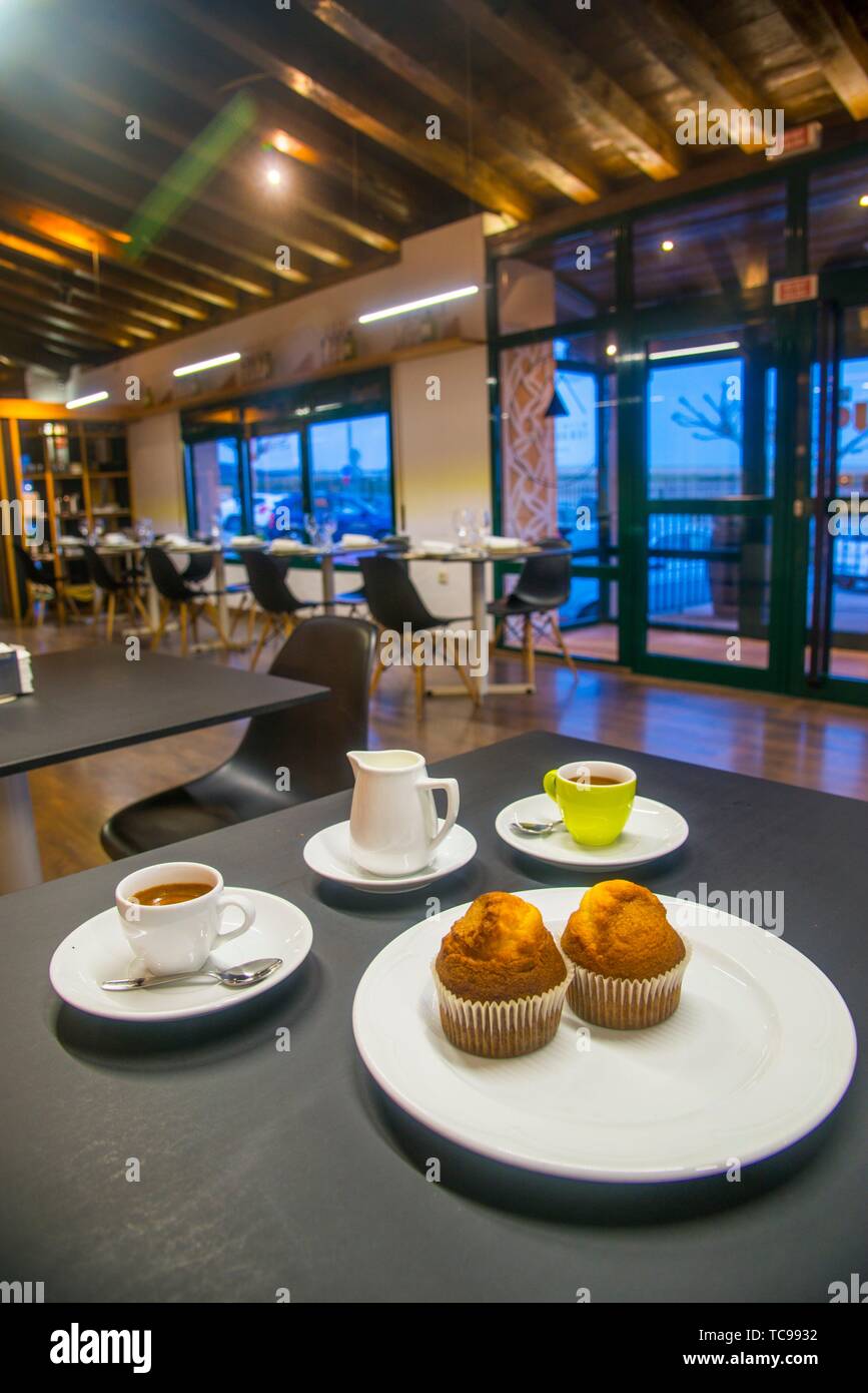 Zwei Tassen Kaffee, Milch und Muffins in einer Cafeteria. Stockfoto