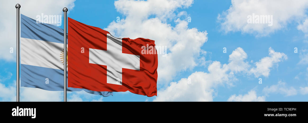 Argentinien und Schweiz Flagge im Wind gegen Weiße bewölkt blauer Himmel zusammen. Diplomatie Konzept, internationale Beziehungen. Stockfoto