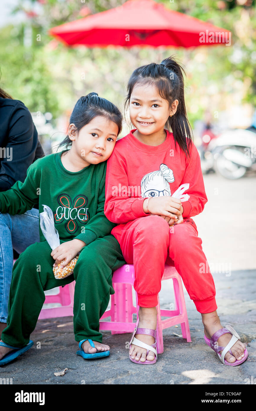 Zwei hübsche kleine kambodische Mädchen hängen zusammen in der Nähe Des Königlichen Palastes in Phnom Penh, Kambodscha. Stockfoto