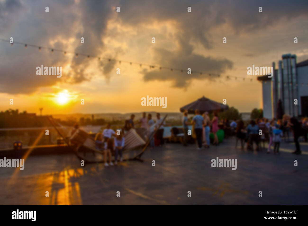 Defokussierten Leute, die Open air Summer Party auf dem Dach. Warme Sonne Licht am Abend. Stockfoto