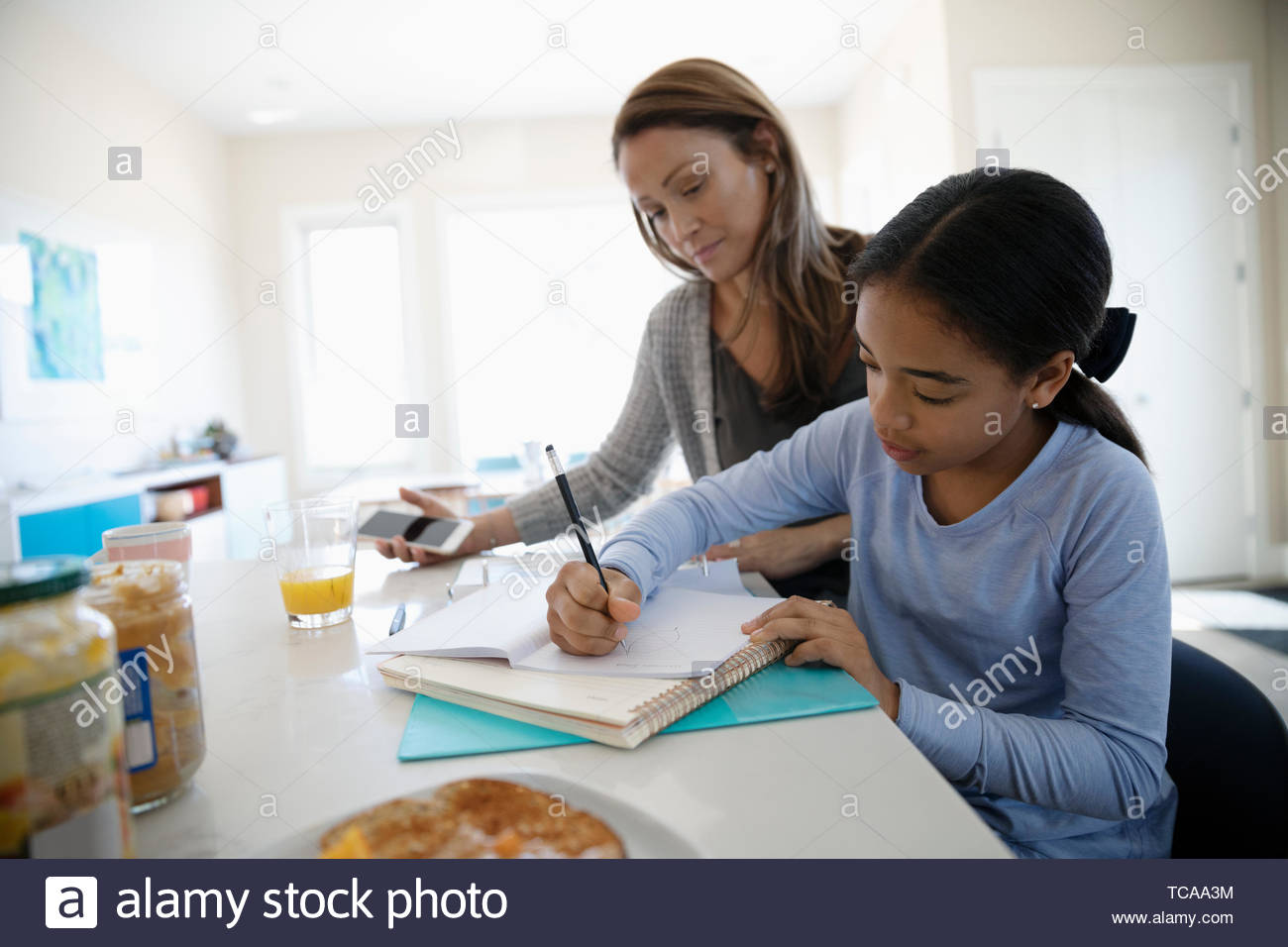 Mutter Tochter helfen bei den Hausaufgaben in der Küche Stockfoto