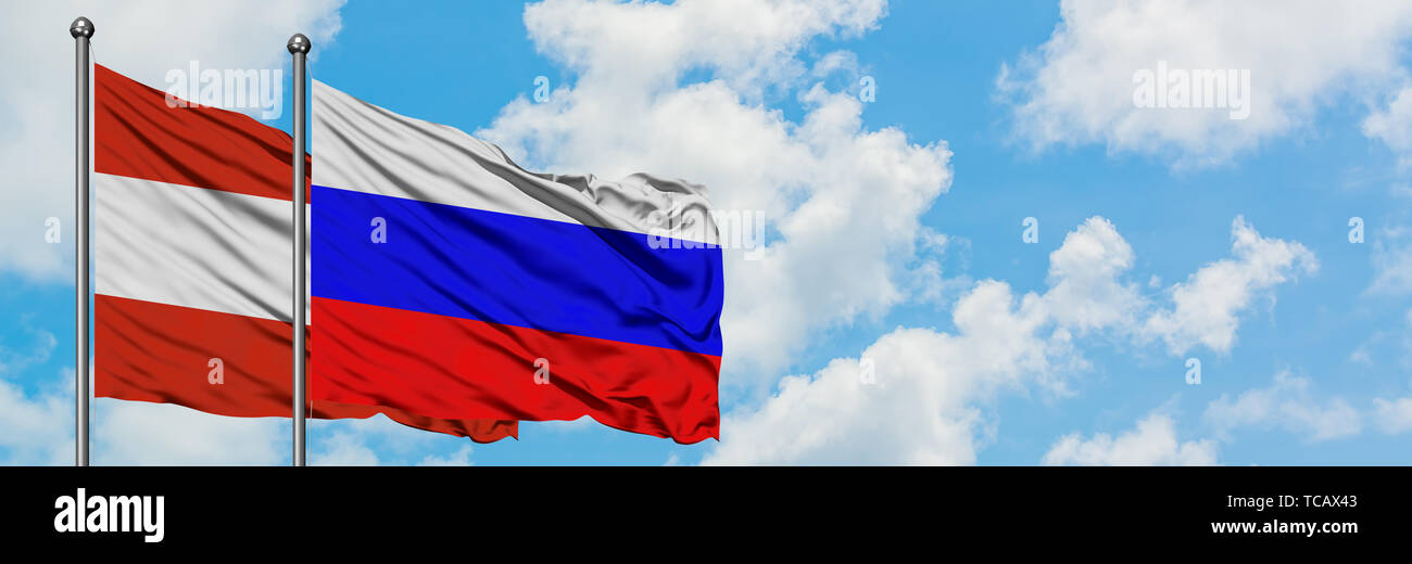 Österreich und Russland Flagge im Wind gegen Weiße bewölkt blauer Himmel zusammen. Diplomatie Konzept, internationale Beziehungen. Stockfoto