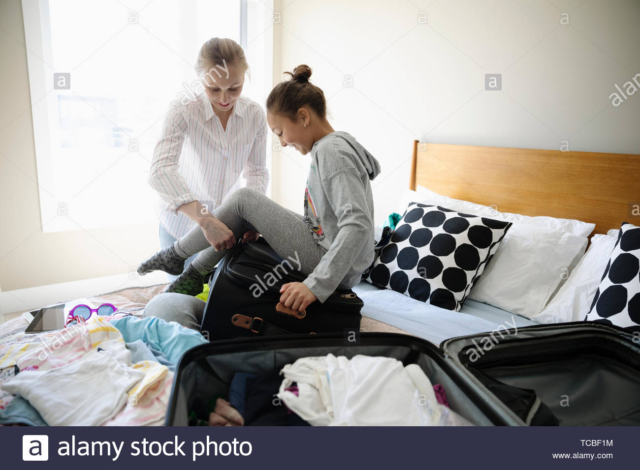 Mutter und Tochter packen Koffer für den Urlaub auf dem Bett Stockfoto