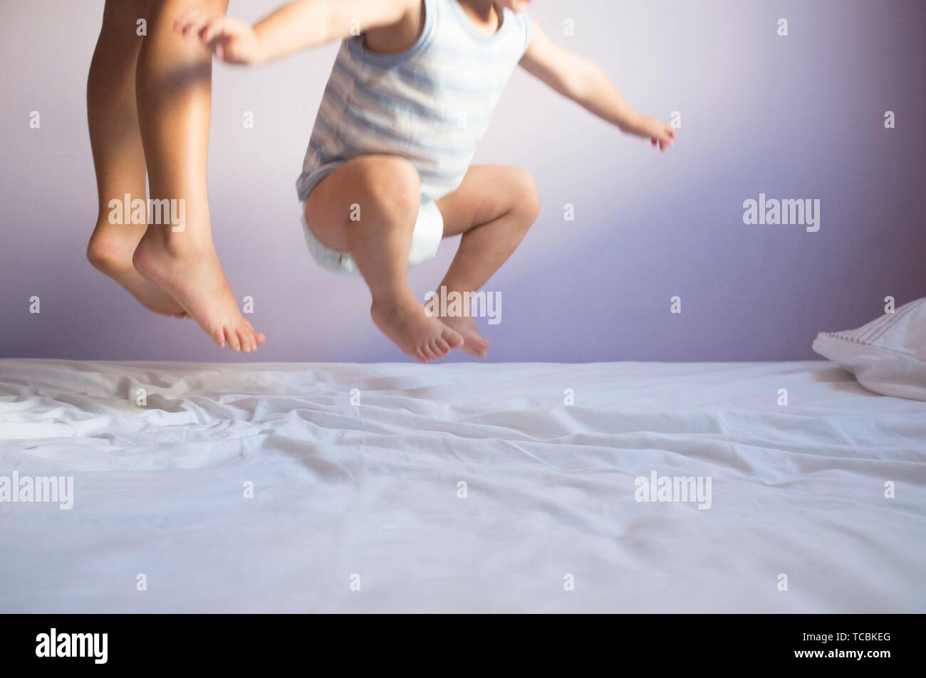 Kinder springen auf dem Bett. Bewegung verwischt. Stockfoto