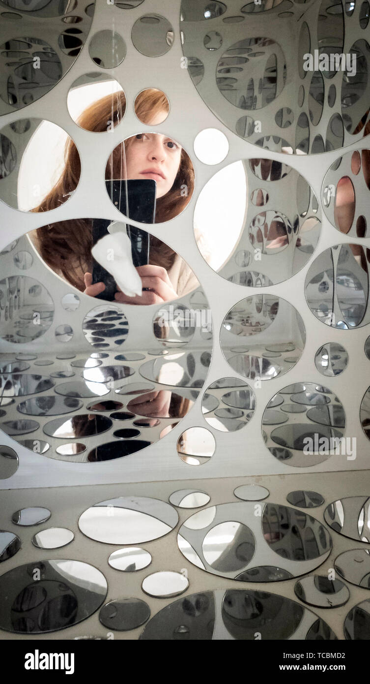 Die Aussicht von Mobile Künstler Raphaela Frangou des Telefons als Sie nimmt ein Foto von sich selbst reflektiert, das durch die Spiegel, die in ihrer Kunst mit dem Titel Träume gehen getrennte Wege, die Teil der Bildenden Kunst Grad zeigen, an der Universität von Leeds. Stockfoto