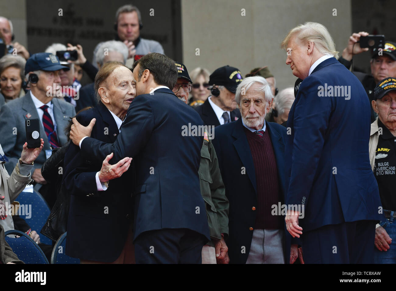 Colleville Sur Mer, Frankreich. 06 Juni, 2019. Der französische Präsident Emmanuel Längestrich, umfasst ein Weltkriegveteran nach ihm die Verleihung des französischen Verdienstordens als US-Präsident Donald Trump auf während einer Gedenkfeier anlässlich des 75. Jahrestag des D-Day in der Normandie amerikanische Friedhof und Denkmal Juni 6, 2019 in Colleville-sur-Mer, Frankreich aussieht. Tausende haben liefen auf die Normandie das 75-jährige Jubiläum der Operation Overlord, die Invasion der Alliierten im Zweiten Weltkrieg allgemein als D-Day bekannt zu gedenken. Credit: Planetpix/Alamy leben Nachrichten Stockfoto