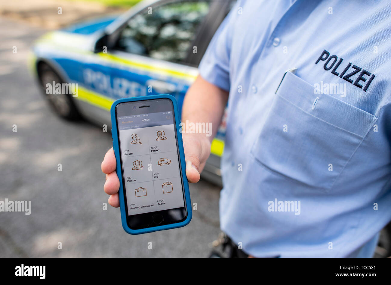 07. Juni 2019, Nordrhein-Westfalen, Dortmund: ein Polizist hält ein neues Smartphone mit einem neuen mobi. Kom-App für die Polizei in der Hand. Mit dieser App können Sie die entsprechenden Daten schnell können während des Betriebs angezeigt. Die Polizei in Nordrhein-Westfalen startet ein Pilotprojekt mit neuen Smartphones und spezielle Apps für die Arbeit der Polizei. Die Geräte werden zunächst von drei Behörden geprüft werden. Das Projekt wird zu einem späteren Zeitpunkt erweitert werden. NRW-Innenminister Reul (CDU) stellt die neuen Geräte und die damit verbundenen Chancen für die Polizei in Nordrhein-Westfalen. Foto: Guido Kirchner/dpa Stockfoto