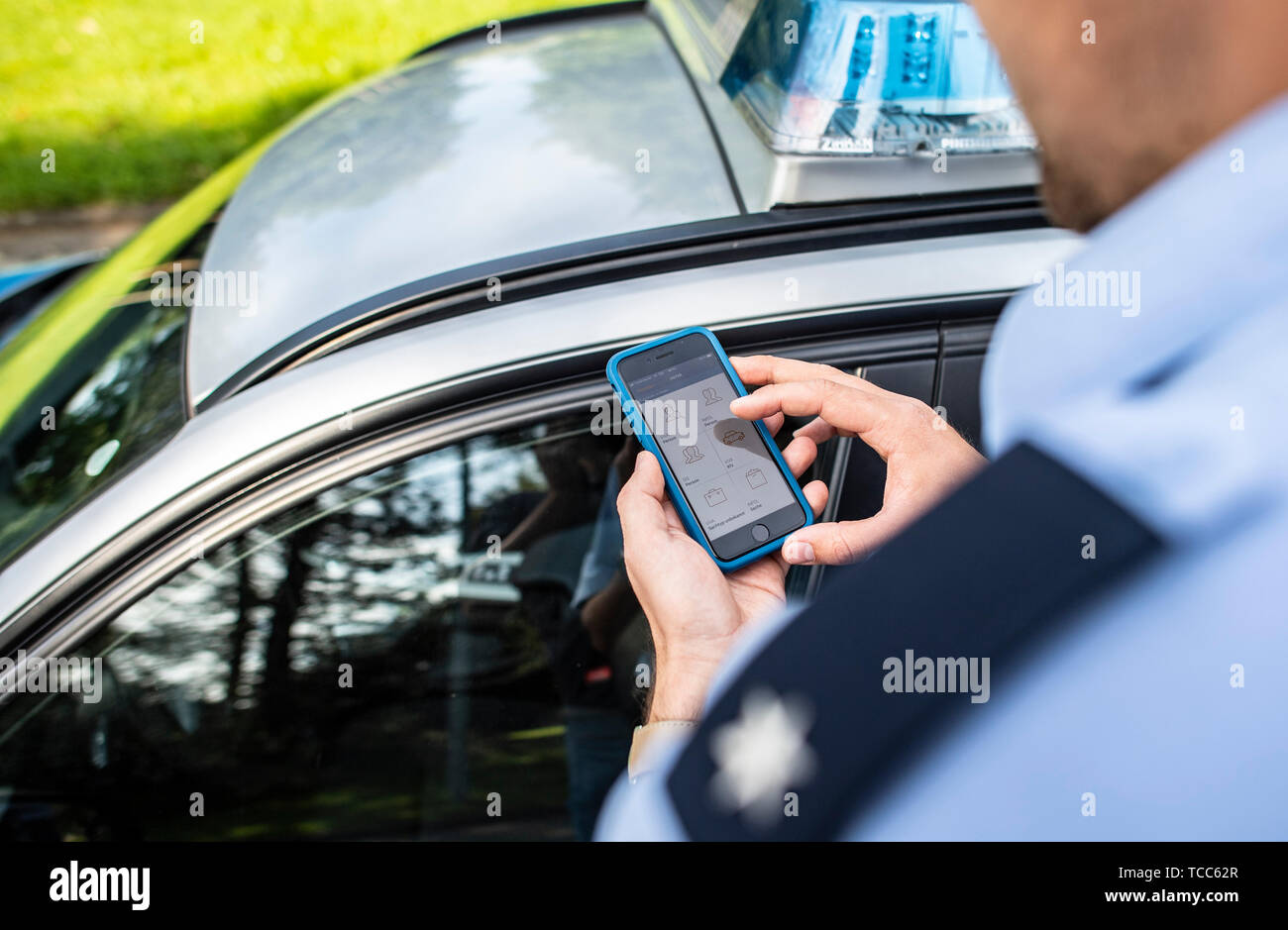 07. Juni 2019, Nordrhein-Westfalen, Dortmund: ein Polizist hält ein neues Smartphone mit einem neuen mobi. Kom-App für die Polizei in der Hand. Mit dieser App können Sie die entsprechenden Daten schnell können während des Betriebs angezeigt. Die Polizei in Nordrhein-Westfalen startet ein Pilotprojekt mit neuen Smartphones und spezielle Apps für die Arbeit der Polizei. Die Geräte werden zunächst von drei Behörden geprüft werden. Das Projekt wird zu einem späteren Zeitpunkt erweitert werden. NRW-Innenminister Reul (CDU) stellt die neuen Geräte und die damit verbundenen Chancen für die Polizei in Nordrhein-Westfalen. Foto: Guido Kirchner/dpa Stockfoto