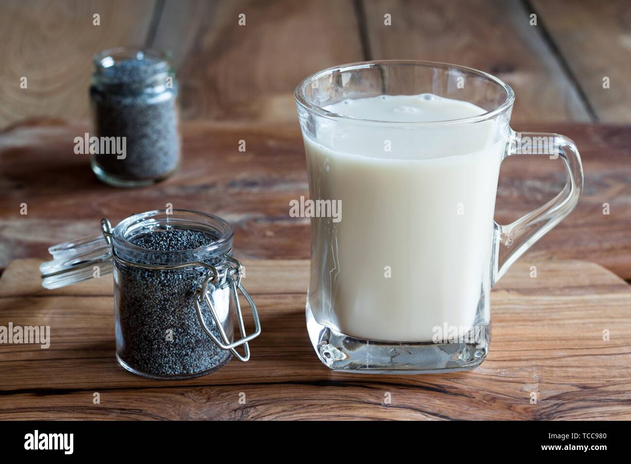 Ein Krug mit Mohn mit einem Glas Mohn Milch. Stockfoto