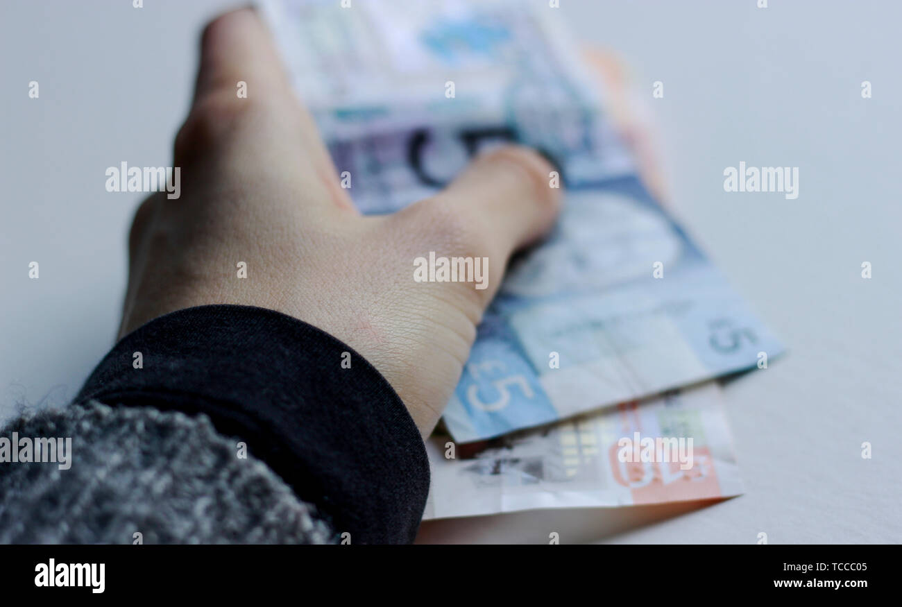 Bank von Schottland Noten, Noten des Pfund Sterling, Mai 2019, UK. Frau mit Pfund Papier schottische Banknoten über isolierte Hintergrund. Stockfoto