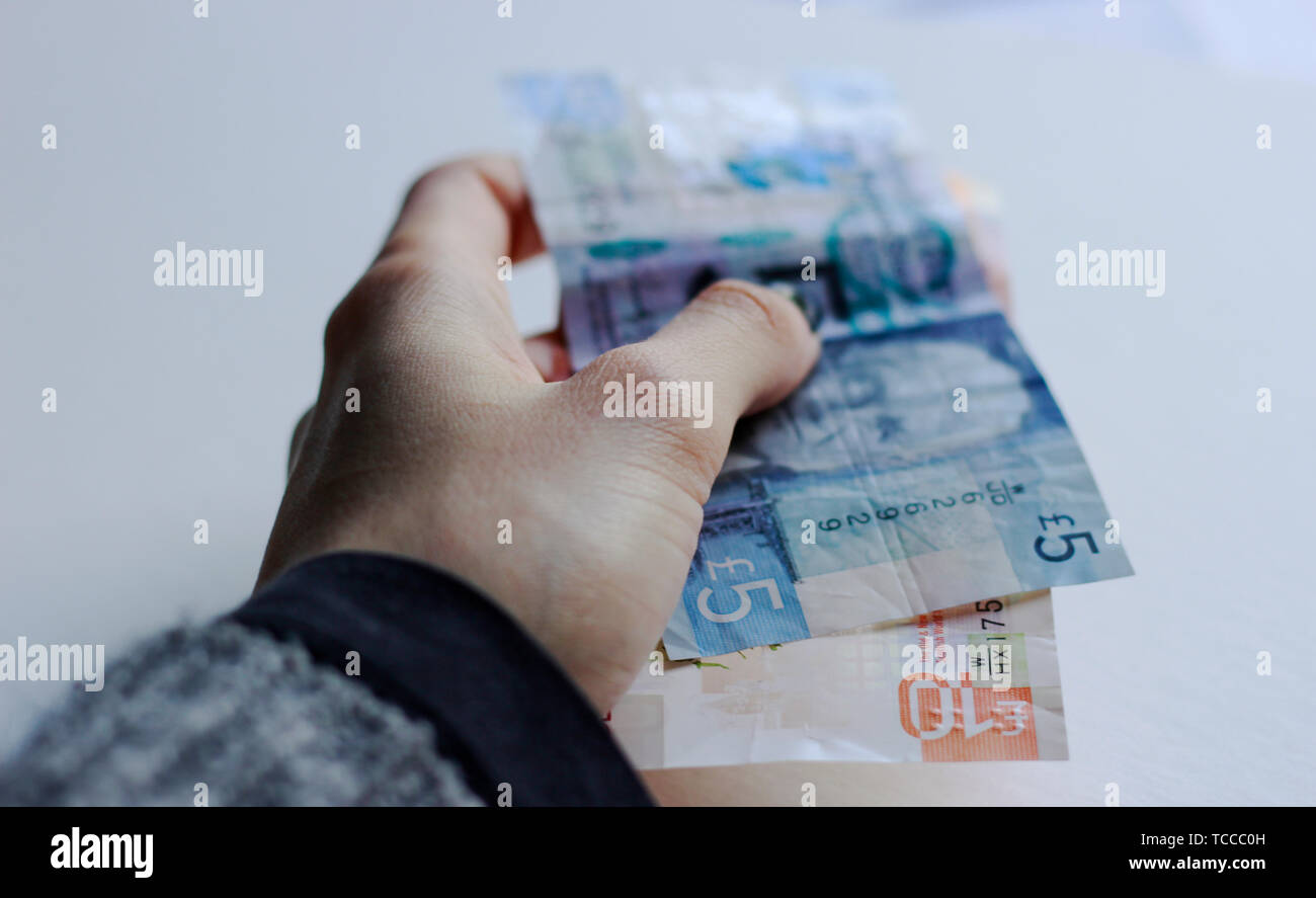 Bank von Schottland Noten, Noten des Pfund Sterling, Mai 2019, UK. Frau mit Pfund Papier schottische Banknoten über isolierte Hintergrund. Stockfoto
