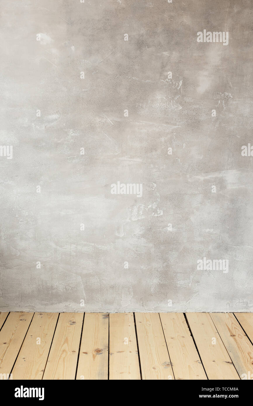 Leere graue Betonwand. Holzboden. Freier Platz für Text. Stockfoto