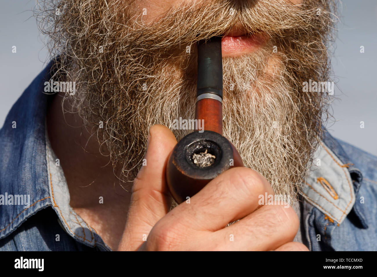 Bärtiger Mann mit einem rauchenden Pfeife im Mund, close-up Stockfoto