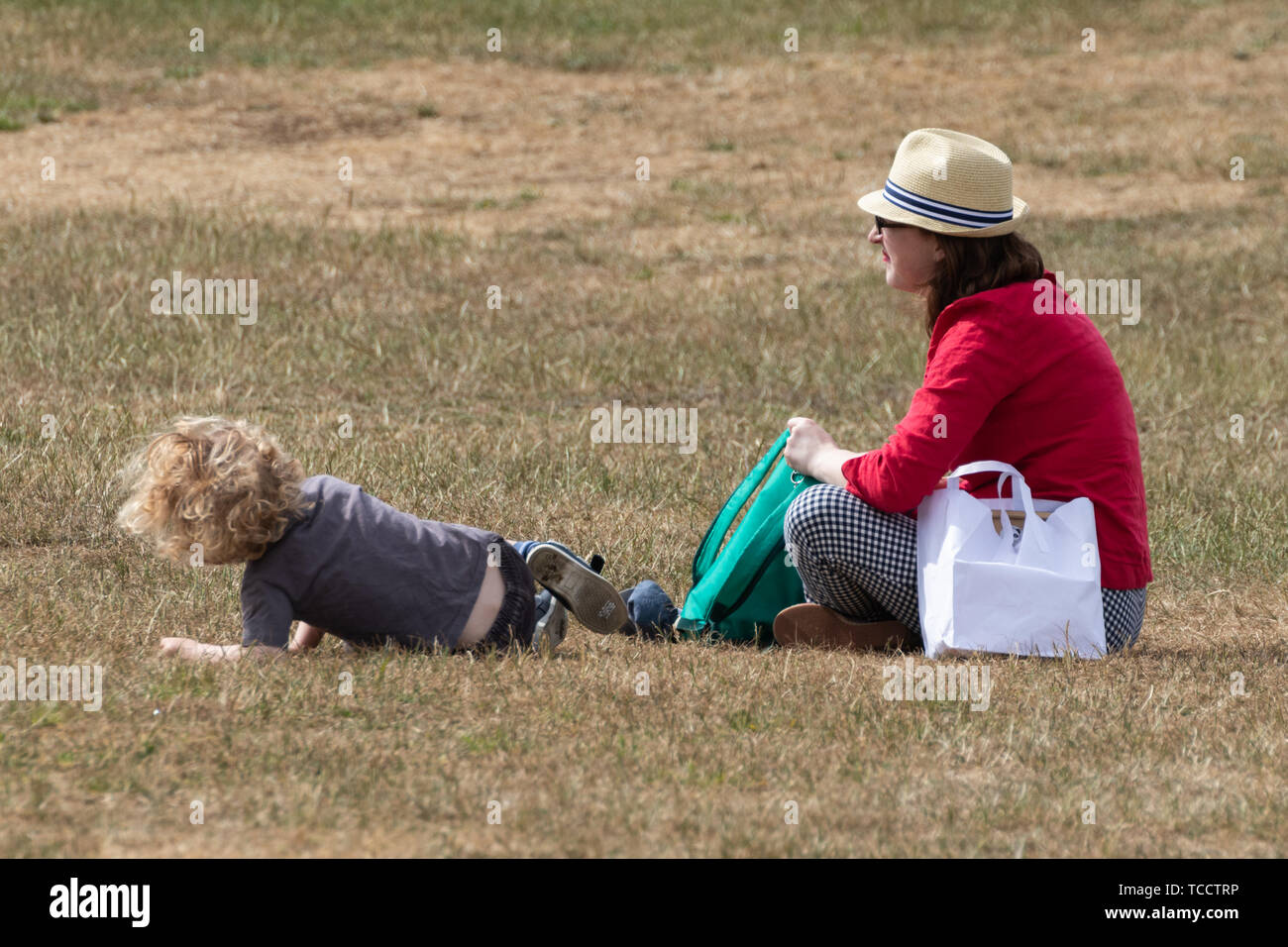 Eine Mutter und Sohn saß auf dem Rasen im Park Stockfoto