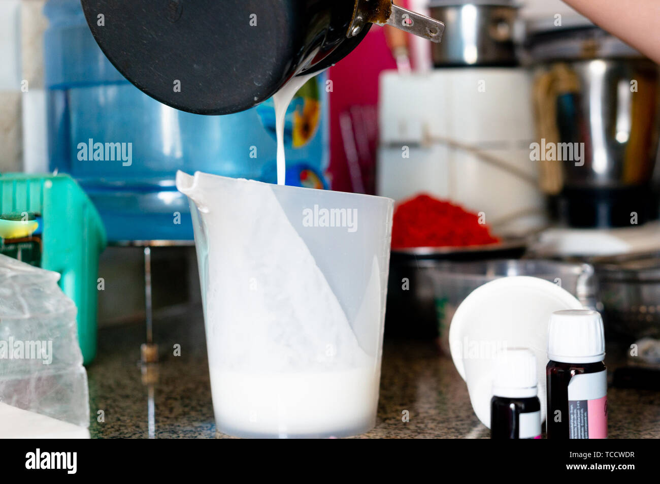 Molton soap Basis geschüttet wurde von einem schwarzen Pan in einen Messbecher Stockfoto