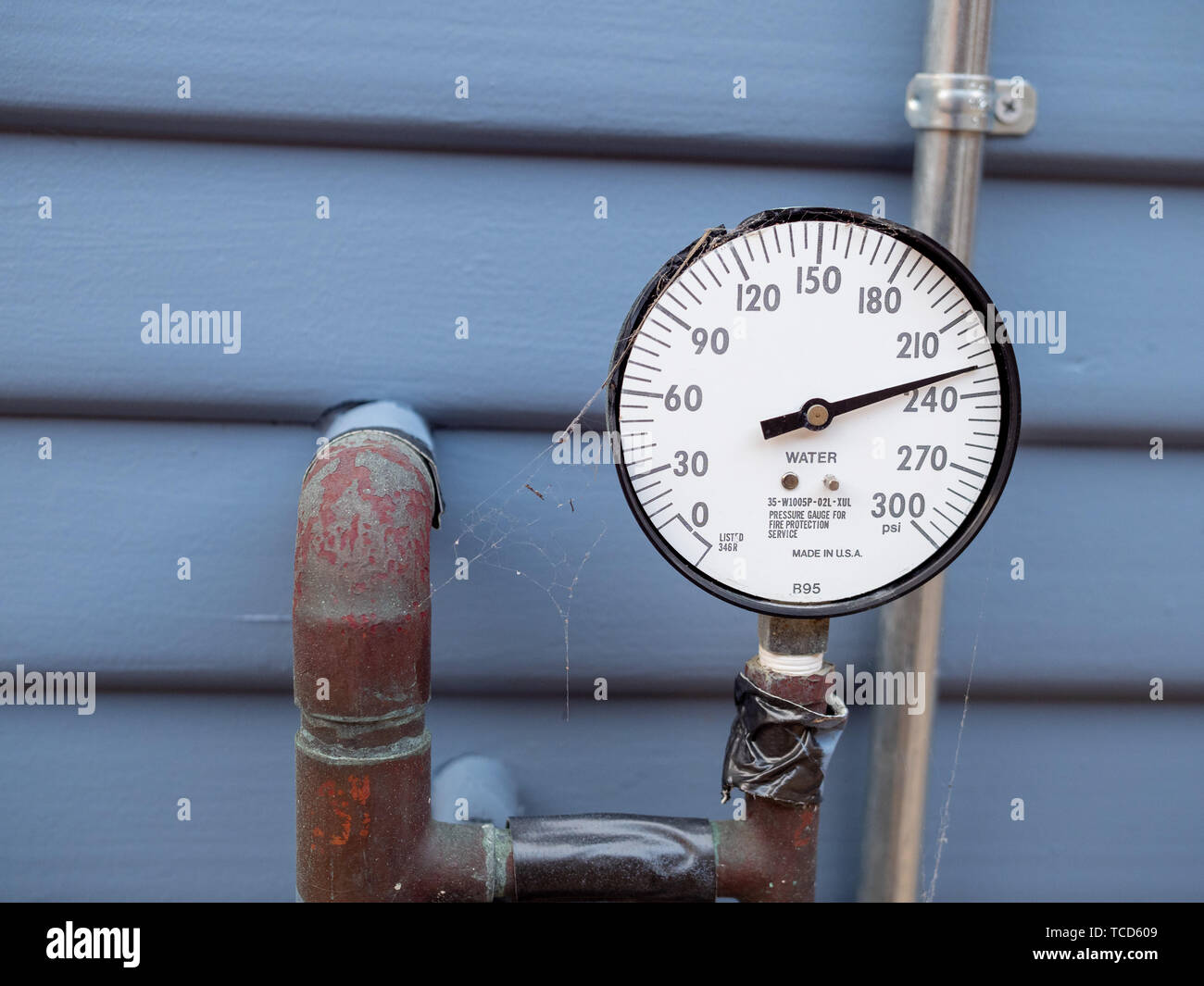 Wasser Manometer Manometer mit Spinnweben und rostige Rohre und Band außerhalb von zu Hause. Mangelnde Sorgfalt Stockfoto