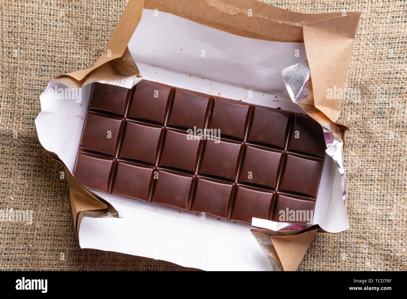 Close-up Schokolade in geöffneten Wrapper auf sackleinen liegt. Stockfoto
