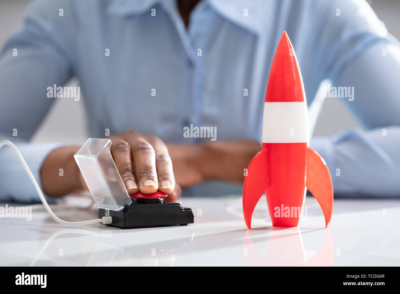 Die Geschäftsfrau Hand mit Raketen durch Drücken der roten Taste Stockfoto