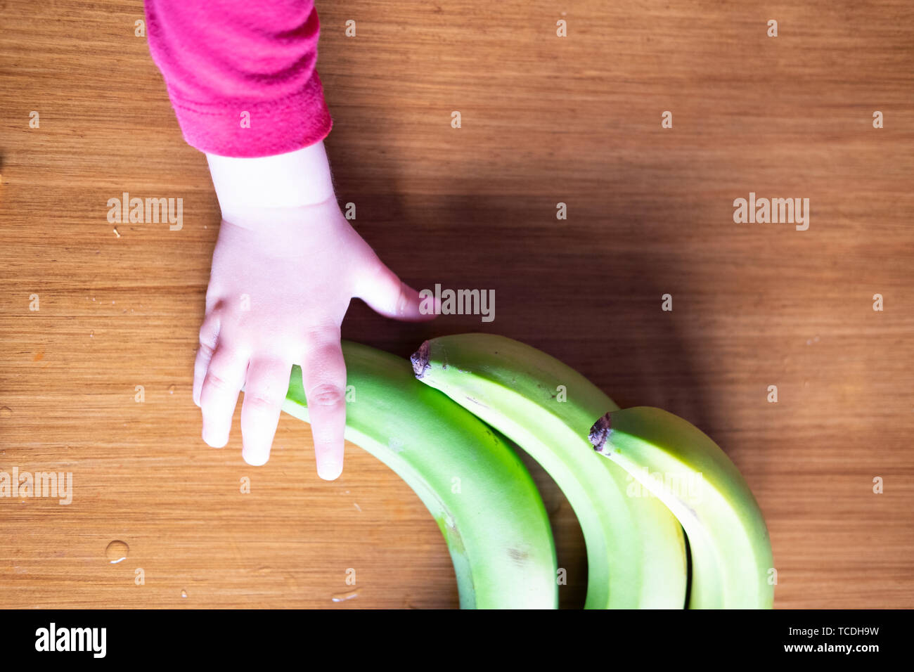 Baby s Hand manipulieren von verschiedenen Früchten auf einem Holztisch Stockfoto