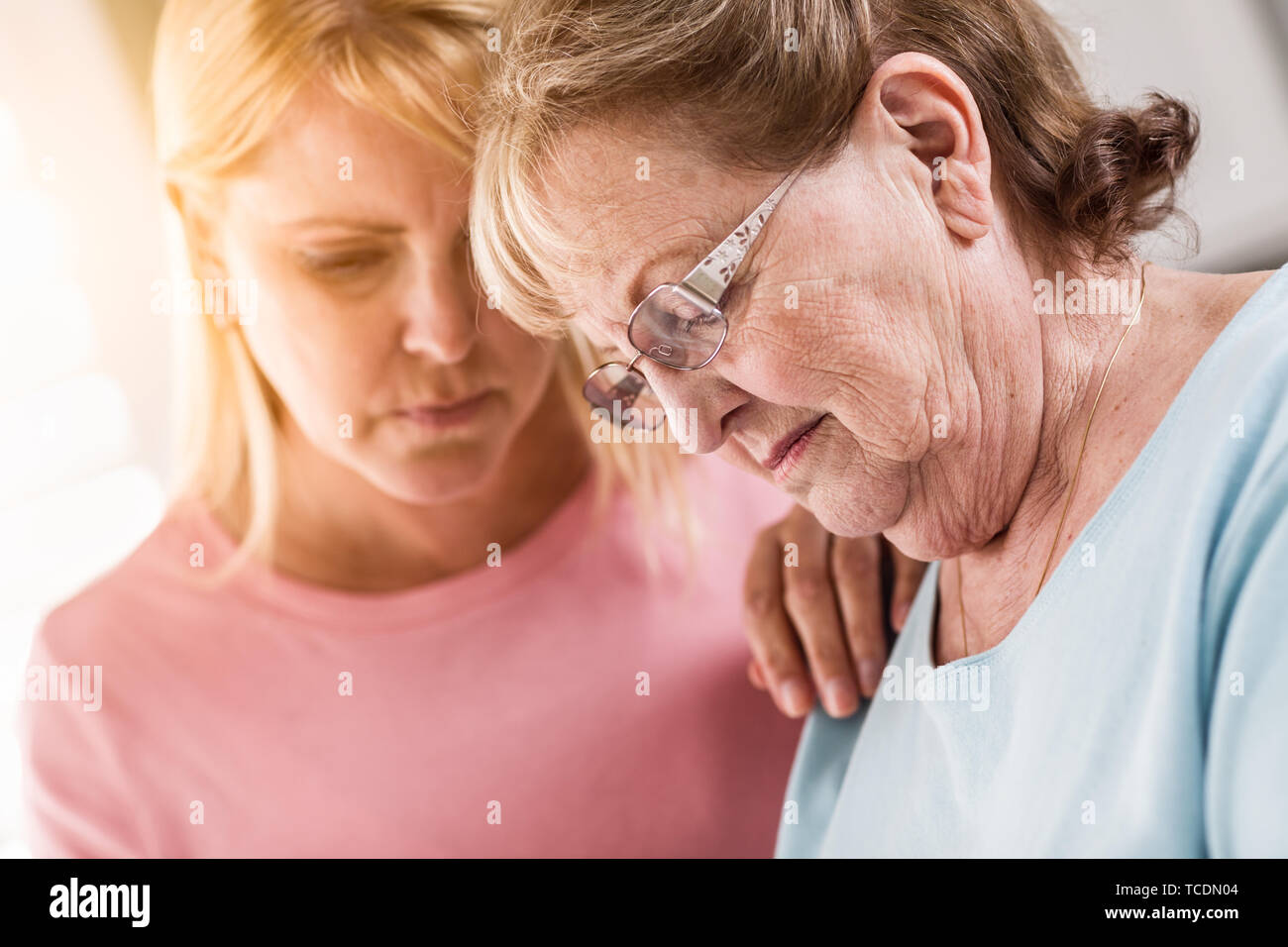 Junge Frau tröstet traurige Senior Erwachsenfrau. Stockfoto
