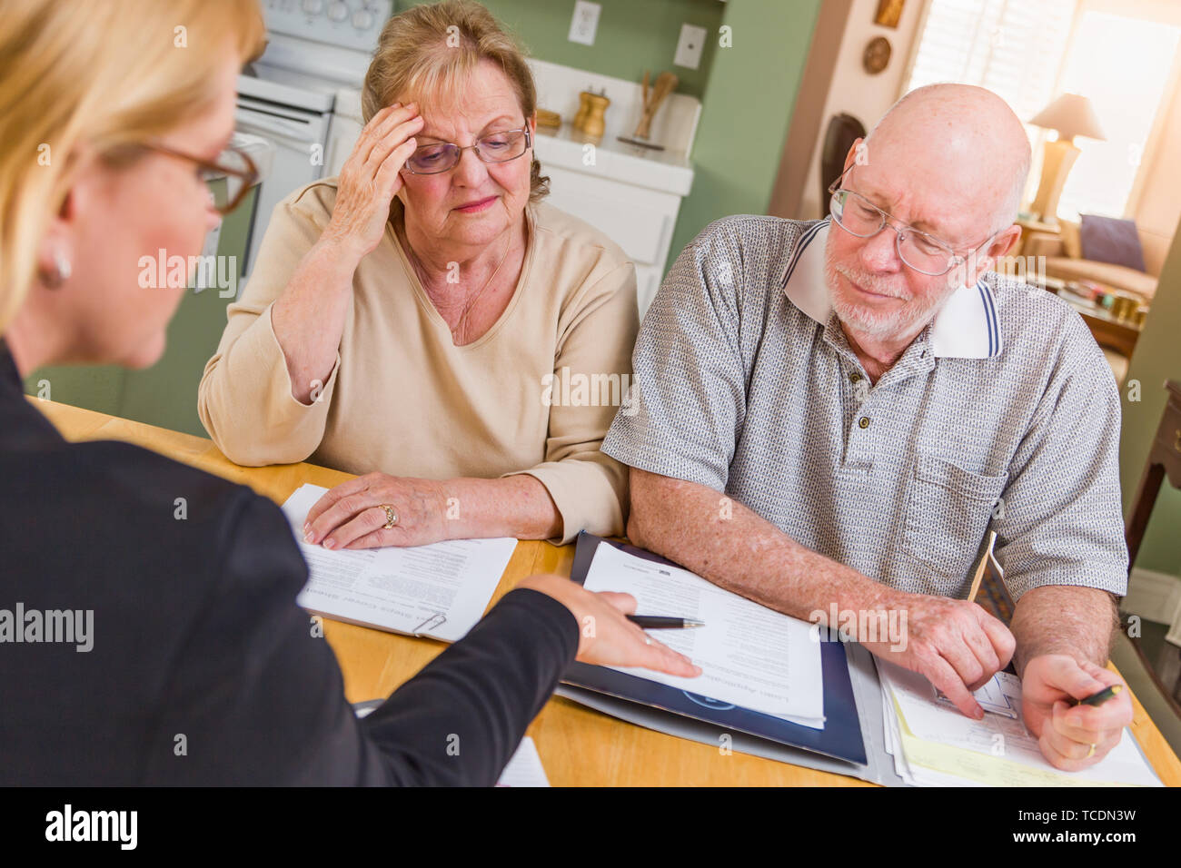 Senior nach Paar über Dokumente in Ihrem Haus mit Agenten zu signieren. Stockfoto