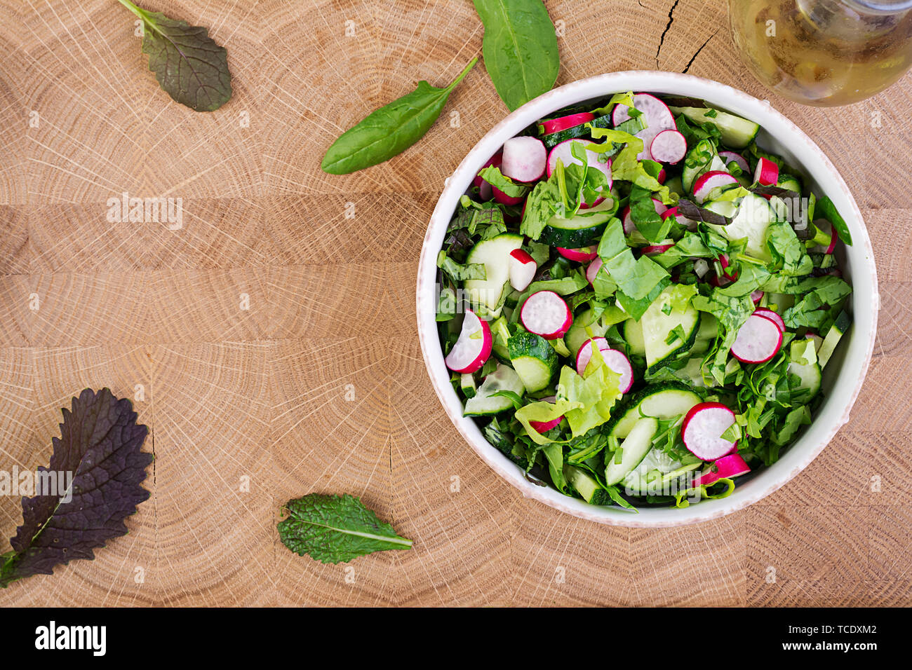 Frischer Salat aus Gurken, Radieschen und Kräutern. Flach. Ansicht von oben Stockfoto