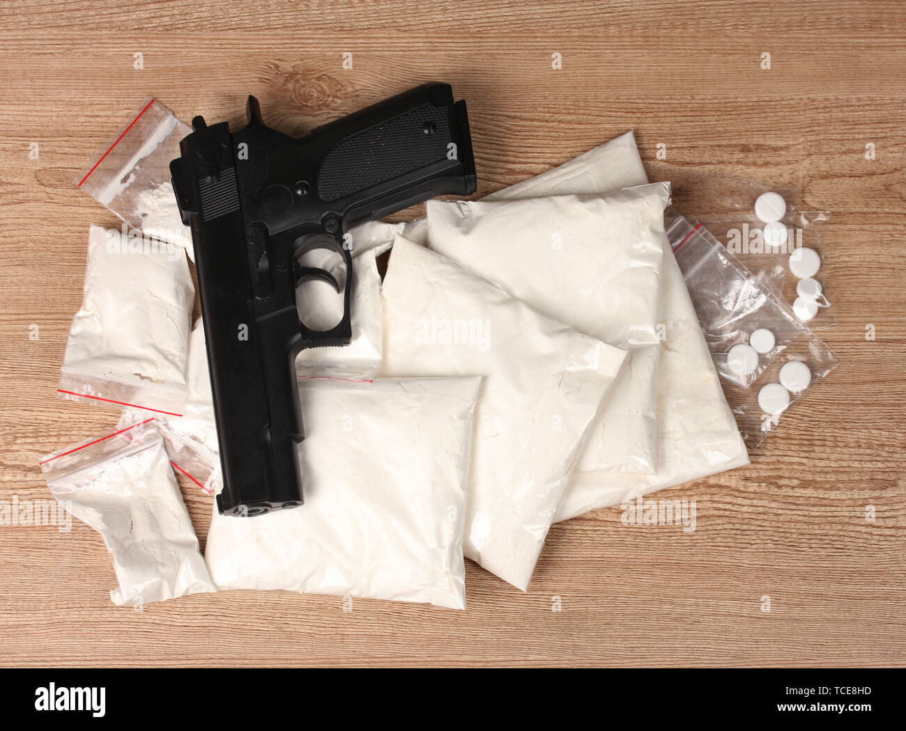 Kokain und Marihuana in Pakete und Pistole auf hölzernen Hintergrund Stockfoto