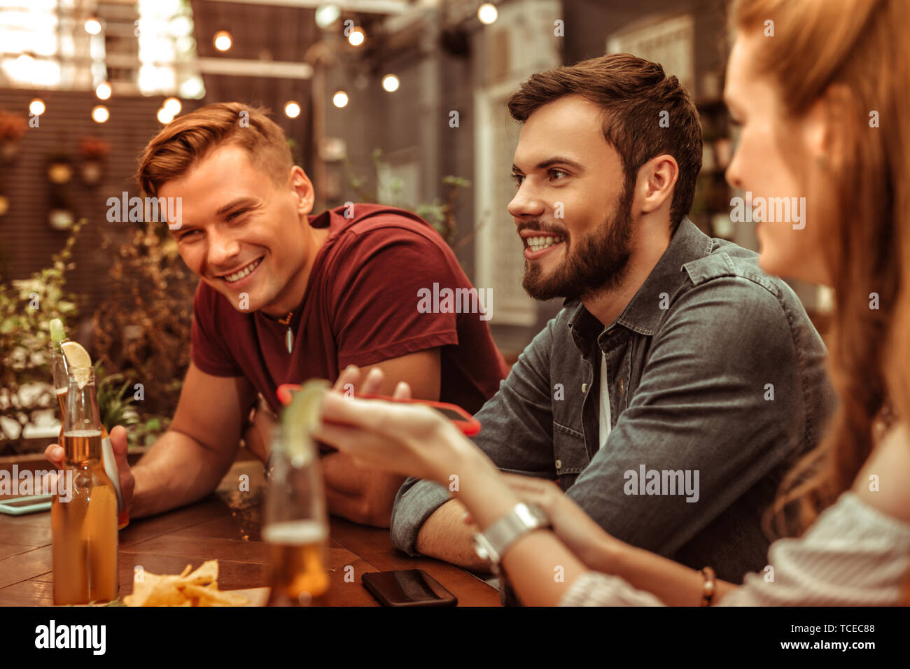 Lächelnde Menschen. Lächeln strahlend attraktiven gerne stilvolle junge Erwachsene zwei Männer an der Bar sitzen Stockfoto