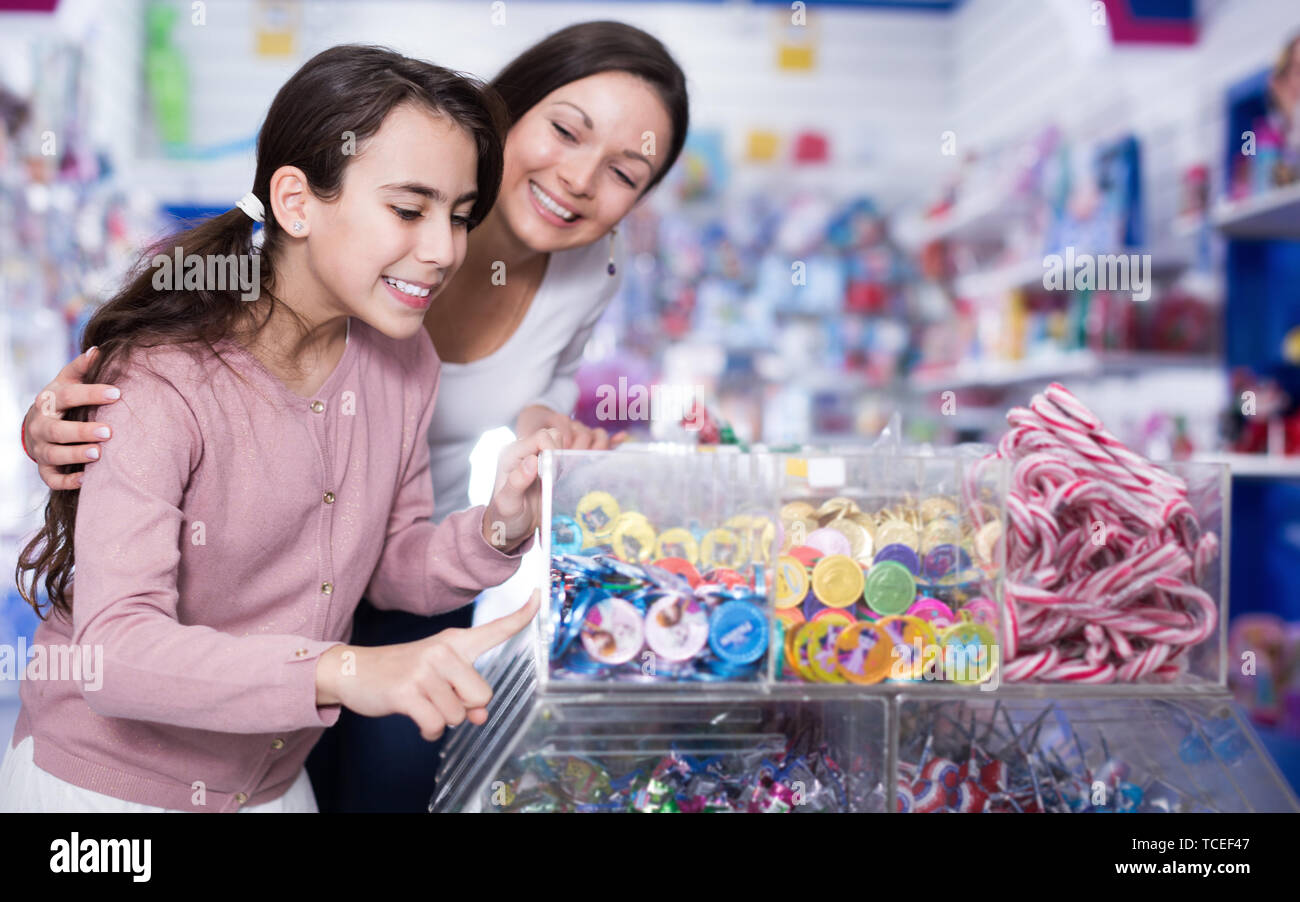 Frau mit lächelnde Mädchen kaufen Süßigkeiten in der Candy shop Stockfoto