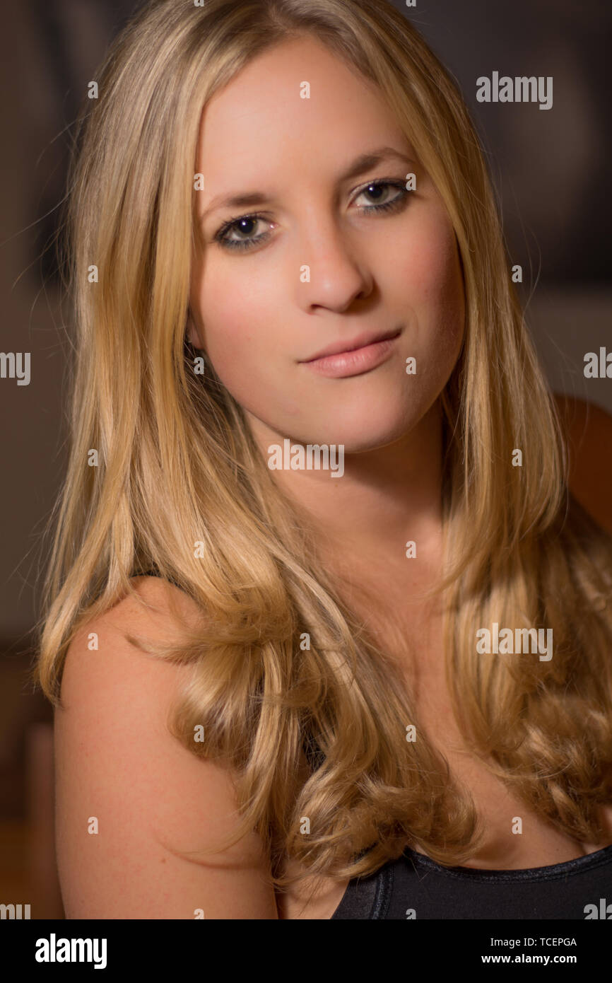 Eine blonde junge Frau Frauen Kopf geschossen mit einem schüchternen Lächeln und natürliches Aussehen. Stockfoto