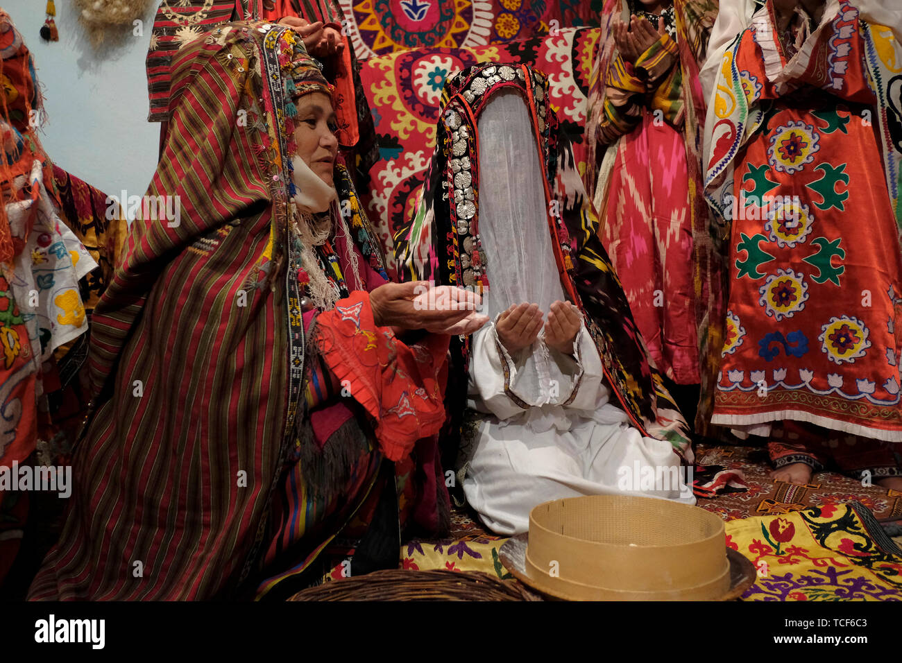 Usbekische Braut mit traditioneller kokoschnik tillya-kosh oder tilla kosh Braut Stirndekoration mit einem gauzy Schleier bedeckt, um das Gesicht der Braut vor indiskreten Augen und Seide bestickt Kostüm im Surkhandarya-Stil in der Stadt Jarkurgan in Surkhandarya oder Surxondaryo Region in Usbekistan zu verstecken Stockfoto