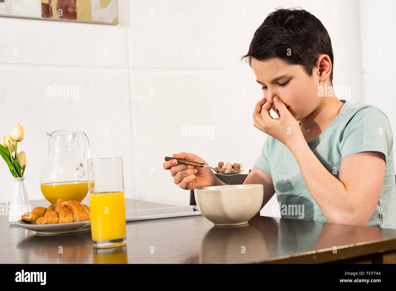 Junge Kneifen Nase Beim Essen Fruhstuck Musli In Der Kuche Stockfotografie Alamy