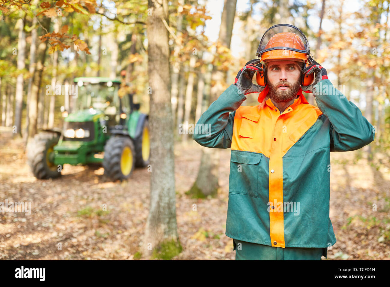 Wald Arbeiter mit Helm und Gehörschutz während Wald arbeiten im Wald Stockfoto
