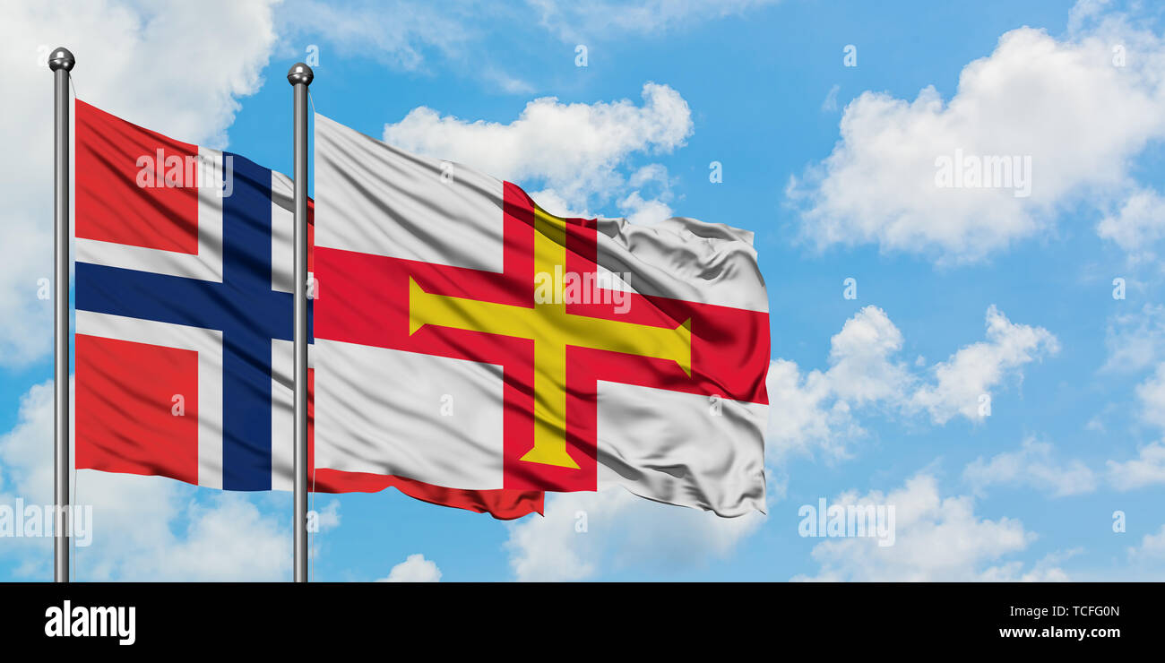 Bouvet Inseln und Guernsey Flagge im Wind gegen Weiße bewölkt blauer Himmel zusammen. Diplomatie Konzept, internationale Beziehungen. Stockfoto